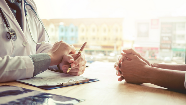 Arzt geht mit Patientin Fragenkatalog durch